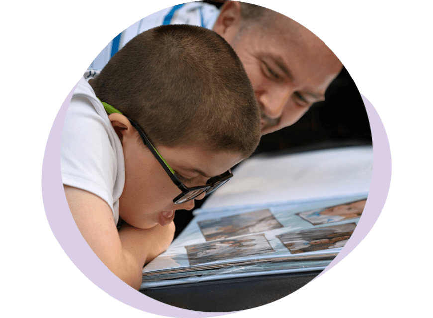 Un enfant qui regarde un album photo avec son papa-L'Accompagnateur